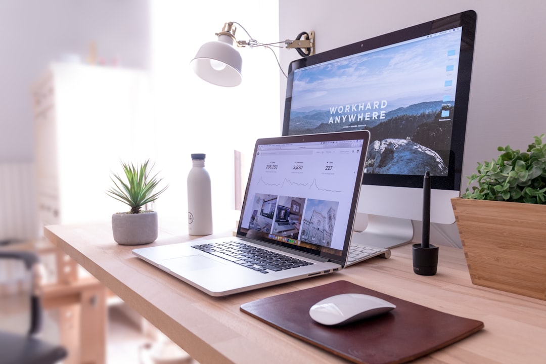 Bureau de travail avec un ordinateur et deux écrans  une lampe de travail